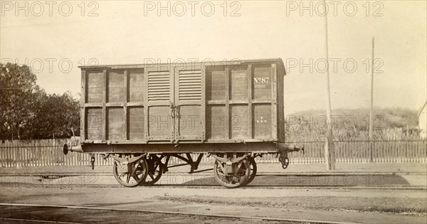 Jamaica Railway wagon. A closed railway wagon inscribed 'No.87', sits on rails at a siding. Jamaica, circa 1895. Jamaica, Caribbean, North America .