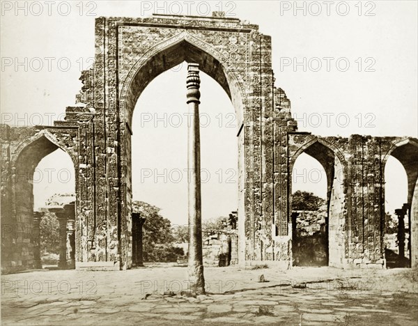 The Iron Pillar at Qutb, circa 1865. The Iron Pillar stands before the ruins of Quwwat-ul-Islam mosque. Like the nearby Ashoka Pillar ('Singh Stambh'), with which it is often confused, the Iron Pillar was erected in around 400AD and has remained mysteriously uncorroded for hundreds of years. This image was pasted into an album compiled in 1889, but appears to date from an earlier period as the pillar is shown without the cement pedestal it had acquired by the 1870s. Delhi, India, circa 1865. Delhi, Delhi, India, Southern Asia, Asia.