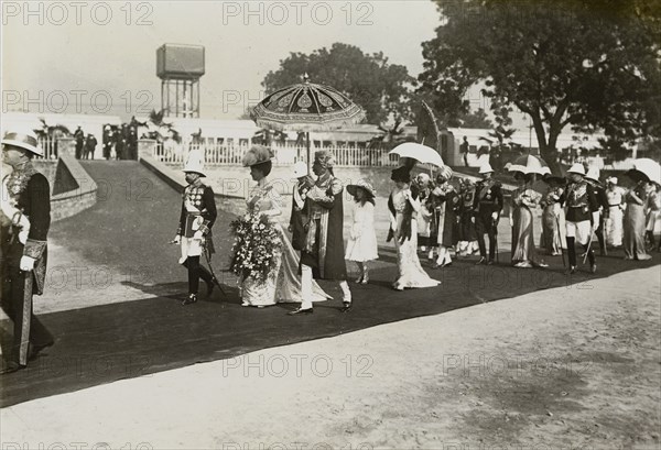 King George V in Delhi. King George V (r.1910-36) and Queen Mary proceed along a red carpet laid out between Selimgarh railway station and the station's reception pavilion. The royal couple had travelled to Delhi for the Coronation Durbar, due to be held there on 12 December. Selimgarh, Delhi, India, 7 December 1911. Selimgarh, Delhi, India, Southern Asia, Asia.