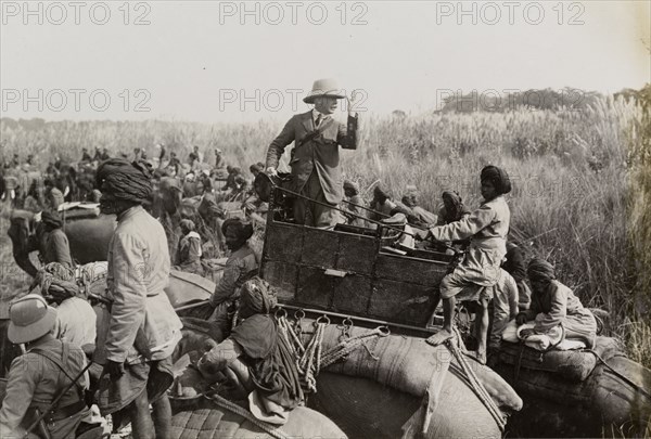 The Duke of Teck gesticulates. The Duke of Teck (1868-1927) stands up in his elephant's howdah, indicating with his hand the number of tigers shot by his son in law, King George V, during a royal hunt in Chitwan Valley. Narayani, Nepal, circa 18 December 1911., Narayani, Nepal, Southern Asia, Asia.