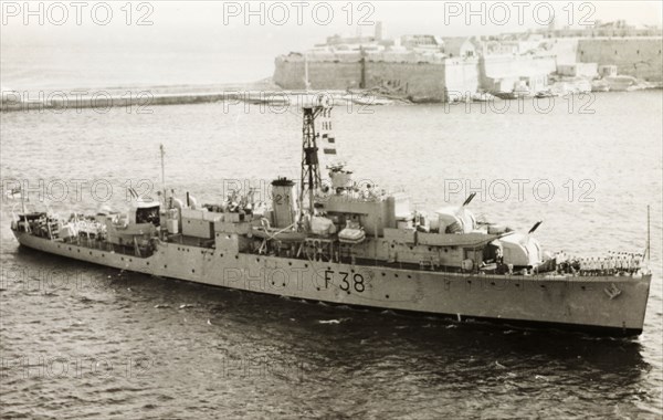 HMS Cygnet, Malta. British naval ship, HMS Cygnet, leaves the Maltese port of Valetta. Valetta, Malta, circa 1950. Valetta, Malta, Malta, Central Europe, Europe .