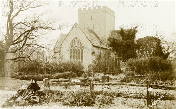 Holy Trinity Church, Poynings. Two small children sit on a log outside Holy Trinity Church. Poynings, England, circa 1890. Poynings, Sussex, England (United Kingdom), Western Europe, Europe .