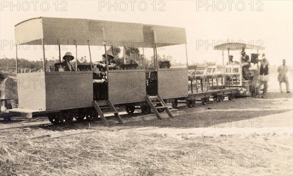 Sukkur light railway train. Two European men sit inside a stationary light railway carriage bound for the construction site of the Sukkur Barrage, an irrigation system stretching over the Indus River. Sukkur, India (Pakistan), 1926. Sukkur, Sindh, Pakistan, Southern Asia, Asia.