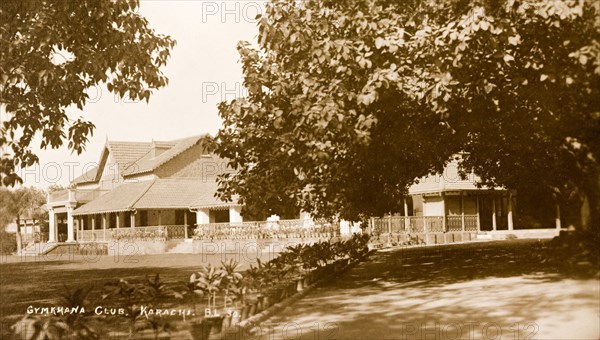 Karachi Gymkhana Club. View across the orderly front lawn of the Karachi Gymkhana Club, a low, colonial-style building with a vernada, which was built in 1886. Karachi, India (Pakistan), circa 1910. Karachi, Sindh, Pakistan, Southern Asia, Asia.