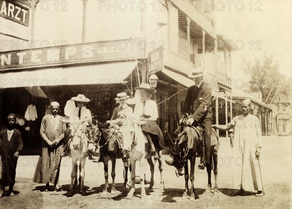 The Lawley children ride donkeys at Port Said. The Lawley children, left to right: Cecilia, 'Ned' (Richard) and Ursula, are supervised by their tutor, Mr. Jose, as they ride donkeys in the centre of town. Port Said, Egypt, circa April 1901. Port Said, Port Said, Egypt, Northern Africa, Africa.