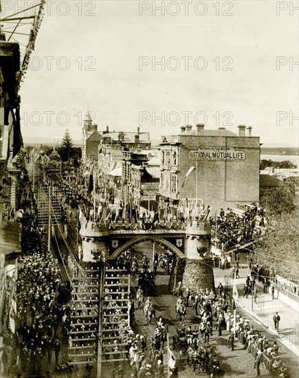 Royal procession beneath the Coach Arch. A procession for the Duke and Duchess of Cornwall and York (later King George V and Queen Mary) passes beneath the Coach Arch at St. George's Terrace. Crowds flank the streets as the parade passes. Perth, Australia, July 1901. Perth, West Australia, Australia, Australia, Oceania.