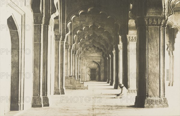 Contemplation at the Moti Masjid, Agra. View of a colonnaded aisle inside the Moti Masjid (Pearl Mosque) at Agra Fort. A man wearing a turban sits cross-legged on the floor beneath the lobed arches, his head bent in contemplation. Agra, United Provinces (Uttar Pradesh), India, circa 1922. Agra, Uttar Pradesh, India, Southern Asia, Asia.