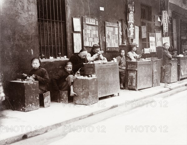 Cantonese seal carvers. A number of Cantonese seal carvers sit at their stalls, waiting for passing business at the side of a city street. Canton, Canton Province (Guangzhou, Guangdong), China, circa 1905. Guangzhou, Guangdong, China, People's Republic of, Eastern Asia, Asia.