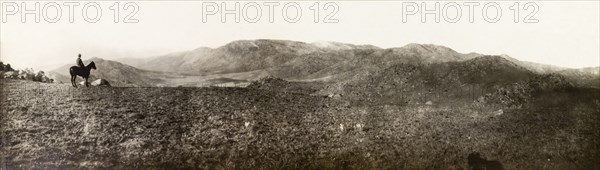 Landscape near Pigg's Peak, Swaziland. Sir Arthur Lawley (1860-1932), Lieutenant Governor of the Transvaal, sits on a horse looking out at the mountainous landscape near Pigg's Peak. Hhohho, Swaziland, 1903. Piggs Peak, Hhohho, Swaziland, Southern Africa, Africa.