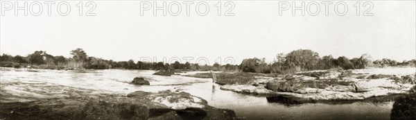 Rapids above Victoria Falls. Arthur Rhodes (brother of Cecil John Rhodes) paddles in the shallows of the Zambezi River above Victoria Falls. Matabeleland, Rhodesia (Matabeleland North, Zimbabwe), circa 1904., Matabeleland North, Zimbabwe, Southern Africa, Africa.