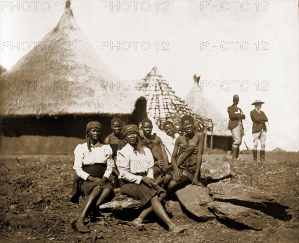 Matabele women at Cecil Rhodes' farm. A group of Matabele (Ndebele) women pose for the camera outside thatched huts at Cecil Rhodes' farm in Sauerdale. Rhodes bought the farm after negotiating an end to the Matabele rebellion, and settled some Matabele people there in part fulfilment of a promise to provide them with decent land. Near Bulawayo, Rhodesia (Matabeleland North, Zimbabwe), circa 1897., Matabeleland North, Zimbabwe, Southern Africa, Africa.