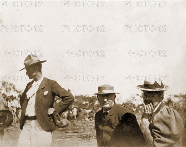 Cecil Rhodes at Sauerdale Farm. Cecil Rhodes (1853-1902) sits between his two European guests, Mr Ross and Mrs Scott, at his farm in Sauerdale. Rhodes bought the farm after negotiating an end to the Matabele rebellion. Near Bulawayo, Rhodesia (Zimbabwe), circa 1897. Bulawayo, Matabeleland North, Zimbabwe, Southern Africa, Africa.