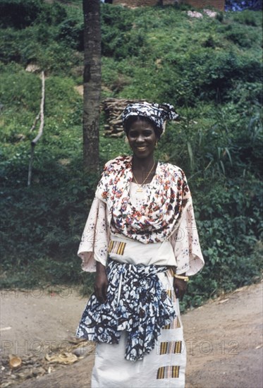 Ghanaian woman in traditional dress. Portrait of a Ghanaian woman, wearing traditional dress decorated with printed patterns. Abandze, Ghana, circa 1958. Abandze, Central (Ghana), Ghana, Western Africa, Africa.