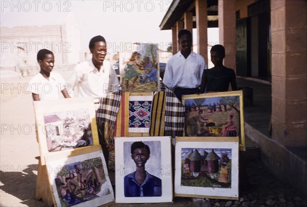 Artwork of Bawku Middle School students. Art students from Bawku Middle School display a selection of their work outdoors. Bawku, Upper East Region, Ghana, circa March 1961. Bawku, Upper East, Ghana, Western Africa, Africa.