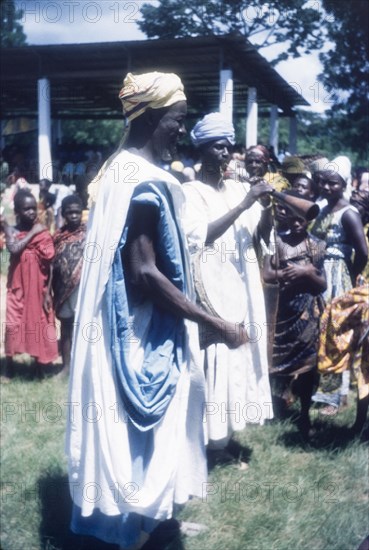 Zongo musicians at a Ngmayem festival. Crowds at an annual Ngmayem harvest festival are entertained by Zongo musicians who play a drum and horn. Odumasi, Ghana, circa 1960. Odumasi, East (Ghana), Ghana, Western Africa, Africa.