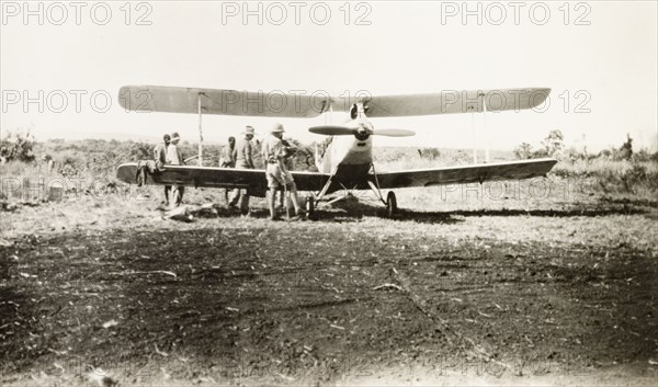 Light aircraft used to spot game. Several men surround a light aircraft used to spot game on safari. Tanganyika Territory (Tanzania), 1927. Tanzania, Eastern Africa, Africa.