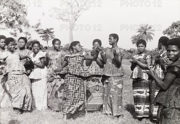 A traditional Asante dance. Female students of a teacher training course clap and sing while one of the group performs a traditional Asante (Ashanti) dance. Asante, Gold Coast (Ghana), circa 1951., Ashanti, Ghana, Western Africa, Africa.