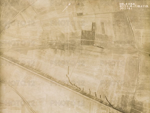 Gun positions and road screens. One of a series of British aerial reconnaissance photographs recording the positions of trenches on the Western Front during the First World War. An original caption indicates gun positions within an area of plantation (the central dark square), and points out the shadows of road screens as a series of dark lines in the bottom right hand corner. Nord-Pas de Calais or Picardie, France, 30 January 1918., Nord-Pas de Calais, France, Western Europe, Europe .