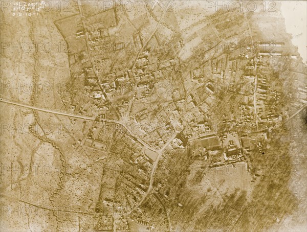 Aerial view of a bomb-damaged village. One of a series of British aerial reconnaissance photographs recording the positions of trenches on the Western Front during the First World War. A square-toothed trench encircles the remains of a bomb-damaged village, surrounded by fields pockmarked with bomb craters. Nord-Pas de Calais or Picardie, France, 3 February 1918., Nord-Pas de Calais, France, Western Europe, Europe .