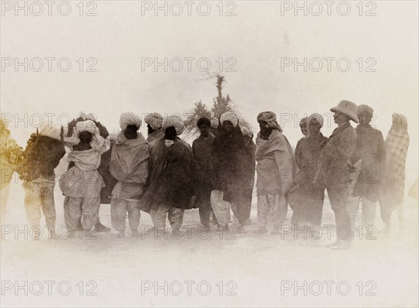 A line of 'zamindars'. Sir Henry Staveley Lawrence, Collector of Karachi, stands beside a line of turbaned Indian men who wear traditional dress. An original caption suggests the men are 'zamindars', landowners who shared taxes collected from tenants on their land with the British authorities. Sind, India (Sindh, Pakistan), circa 1910., Sindh, Pakistan, Southern Asia, Asia.