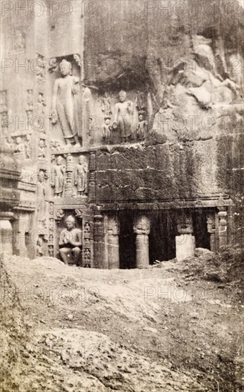 An entrance to the Ajanta caves. Religious figures are carved into the rockface outside a pillared entrance to one of the Ajanta caves, a series of ancient caves that feature Buddhist religious art including ornate frescoes and sculptures. Near Aurangabad, Bombay Presidency (Maharashtra), India, circa 1926. Aurangabad, Maharashtra, India, Southern Asia, Asia.