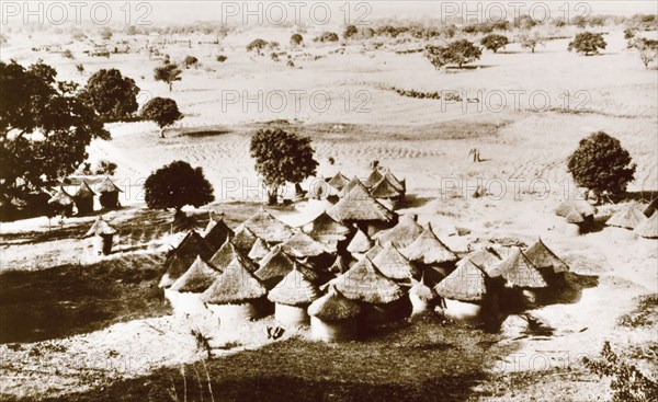 A Gwari village. A Gwari (Gbagi) settlement on the open plains, containing a cluster of round huts with mud walls and thatched roofs. Nigeria, circa 1940. Nigeria, Western Africa, Africa.