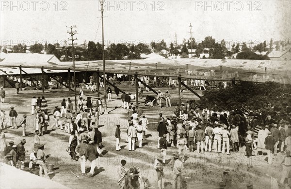 The market place in Kimberley. African diamond mine workers gather in the market place at Kimberley. Lightweight fabric is stretched across a structure made from beams, apparently "muslin to give shade in (the) town compound". Kimberley, South Africa, circa 1897. Kimberley, North Cape, South Africa, Southern Africa, Africa.