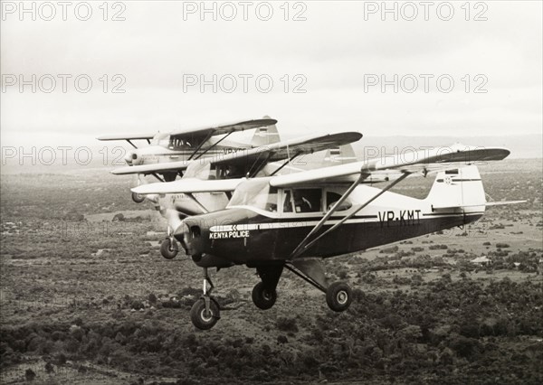 Kenya Police Airwing aircraft. Three light aircraft belonging to the Kenya Police Airwing fly in formation over the Kenyan landscape. Kenya, 1955. Kenya, Eastern Africa, Africa.