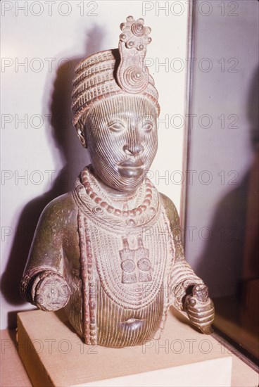 Yoruba bronze sculpture. A bronze sculpture of a head and upper torso, possibly a royal or religious effigy, from the ancient Yoruba city of Ife. The Yoruba custom of sculpting figures flourished during the 14th and 15th centuries, when they began making life-like bronze sculptures. Ife, Nigeria, 1963. Ife, Osun, Nigeria, Western Africa, Africa.