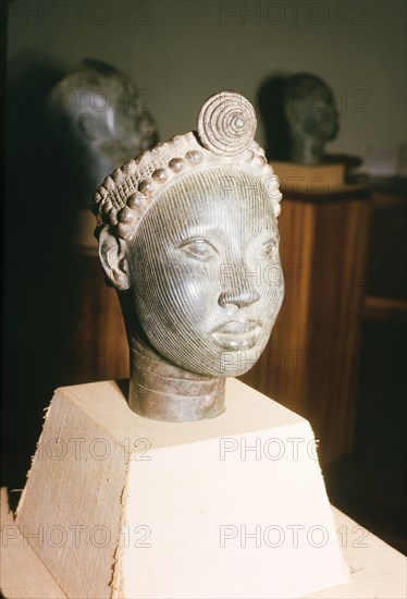 Yoruba bronze sculpture. A bronze sculpture of a head, possibly a royal or religious effigy, from the ancient Yoruba city of Ife. The Yoruba custom of sculpting figures flourished during the 14th and 15th centuries, when they began making life-like bronze sculptures. Ife, Nigeria, 1963. Ife, Osun, Nigeria, Western Africa, Africa.