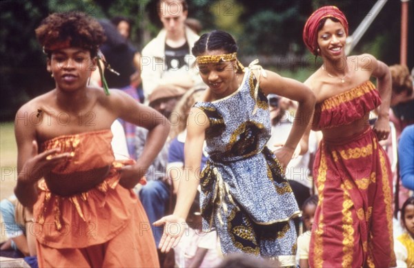 Dancers at the West African Music Village. Female dancers in traditional African dress perform at the West African Music Village, a cultural festival held at the Commonwealth Institute. London, England, 1989. London, London, City of, England (United Kingdom), Western Europe, Europe .