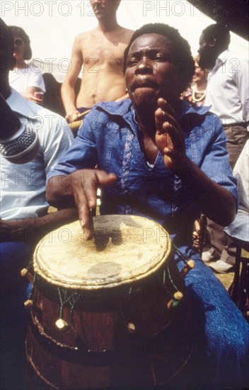 Drummer at the West African Music Village. A musician plays the drums at the West African Music Village, a cultural festival held at the Commonwealth Institute. London, England, 1989. London, London, City of, England (United Kingdom), Western Europe, Europe .