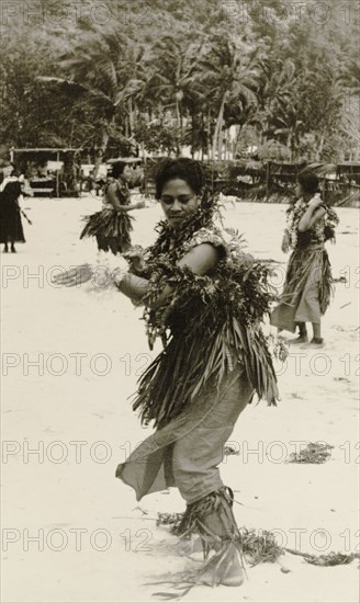 A Fijian dancer. A Fijian woman performs a traditional dance on a beach, dressed in ceremonial attire including a grass skirt worn over a 'sulu' (sarong). Fiji, 1935. Fiji, Pacific Ocean, Oceania.