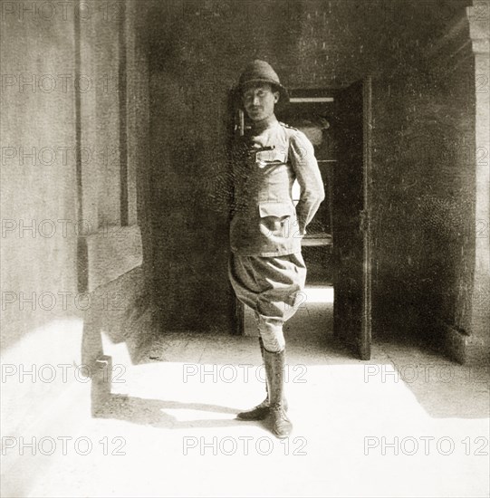 A portrait of Jos Grant. Full-length portrait of Jos Grant, a settler farmer in Kenya and the father of Elspeth Huxley (nee Grant). A captain during the First World War, he poses for the camera in his army uniform with a baton tucked beneath his arm. Kenya, circa 1915. Kenya, Eastern Africa, Africa.