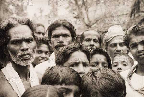 A crowd of Ceylonian men. A crowd of men and boys stare solemnly into the camera. Ceylon (Sri Lanka), 1936. Sri Lanka, Southern Asia, Asia.