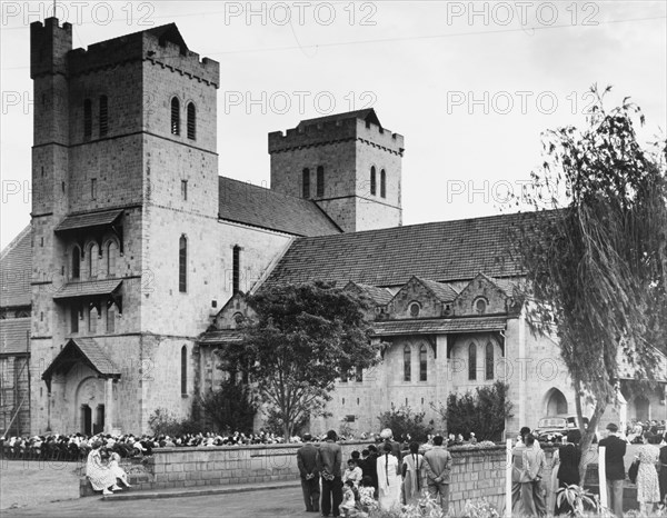 Memorial service for King George VI, Nairobi. A congregation of mourners sit on chairs outside All Saints Cathedral during a memorial service for King George VI, who died in his sleep at Sandringham House, England, on 6 February 1952. Nairobi, Kenya, circa 6 February 1952. Nairobi, Nairobi Area, Kenya, Eastern Africa, Africa.