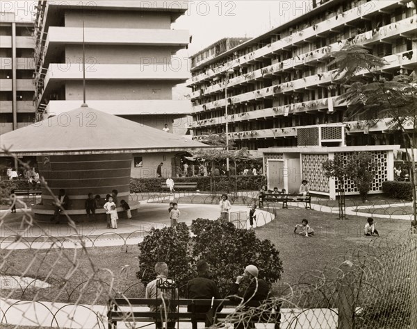 Resettlement blocks in Kowloon. Children play in a fenced park surrounded by multi-storey resettlement blocks. Blocks like these were built all over Kowloon by the British government to re-house 70,000 people after fire destroyed an overcrowded squatter settlement in 1953. Kowloon, Hong Kong, China, 1963. Kowloon, Hong Kong, China, People's Republic of, Eastern Asia, Asia.