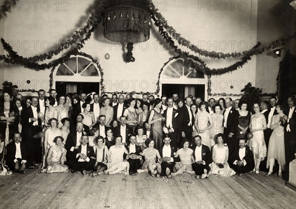 Aftershow party at Orpheus Theatre. Group portrait of officers of the West Yorkshire Regiment (The Prince of Wales's Own) with their wives and cabaret performers at a concert hall, following a performance at the Orpheus Theatre. Mhow, Indore State (Madhya Pradesh), India, March 1929. Indore, Madhya Pradesh, India, Southern Asia, Asia.