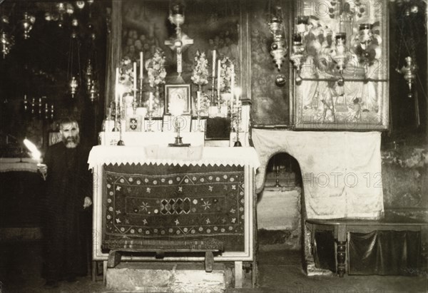 Altar in the Tomb of the Virgin Mary. An altar in the Tomb of the Virgin Mary, enshrined with candles, framed pictures and a cross. Jerusalem, British Mandate of Palestine (Israel), circa 1942. Jerusalem, Jerusalem, Israel, Middle East, Asia.