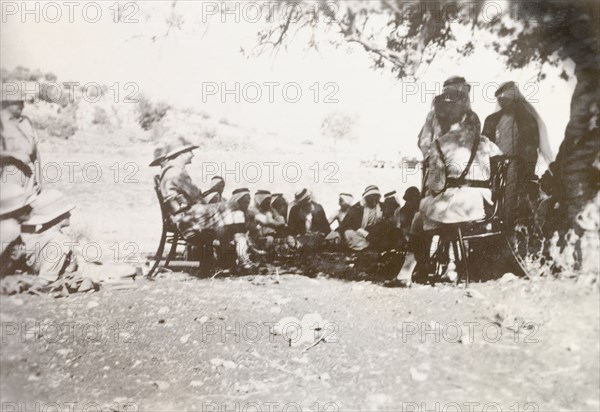 British military questioning Palestinian Arabs. British military officers sit under the shade a tree and question a group of Palestinain Arab detainees. During the period of the Great Uprising (1936-39), an additional 20,000 British troops were deployed to Palestine in an attempt to clamp down on Arab dissidence. British Mandate of Palestine (Middle East), circa 1938., Middle East, Asia.