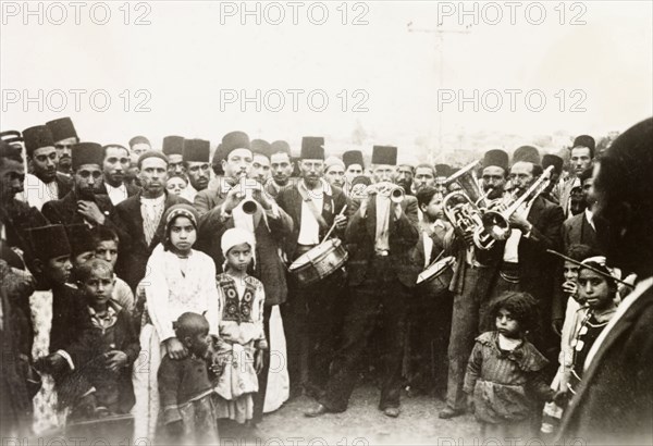 A traditional Arab wedding. Group portrait of male guests, children and musicians at a traditional Arab wedding. British Mandate of Palestine (Middle East), circa 1938., Middle East, Asia.