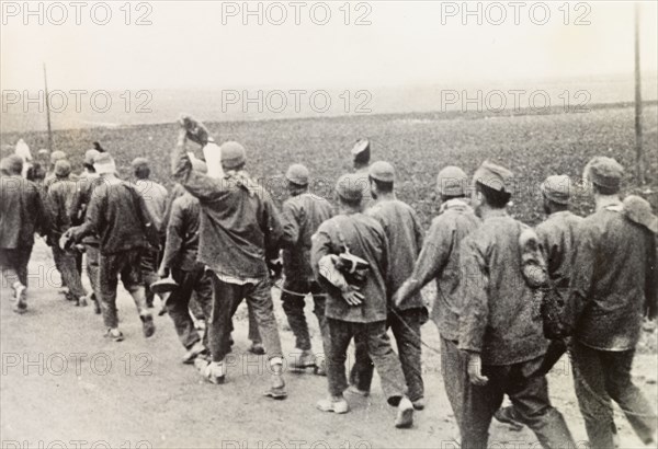 Convicts on way to work, Palestine. A chained group of Arab convicts walk along a road on their way to work during the Great Uprising (1936-39). British Mandate of Palestine (Middle East), circa 1938., Middle East, Asia.