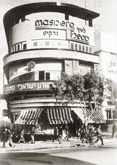 Commercial building on Allenby Road. A modern commercial building with a curved facade on Allenby Road, featuring signs written in both English and Arabic script. Tel Aviv, British Mandate of Palestine (Israel), circa 1938., Tel Aviv, Israel, Middle East, Asia.