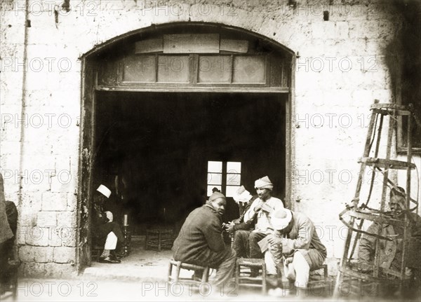 A Palestinian cafe. A group of Arab men socialise in the doorway of a cafe. British Mandate of Palestine (Middle East), circa 1938., Middle East, Asia.