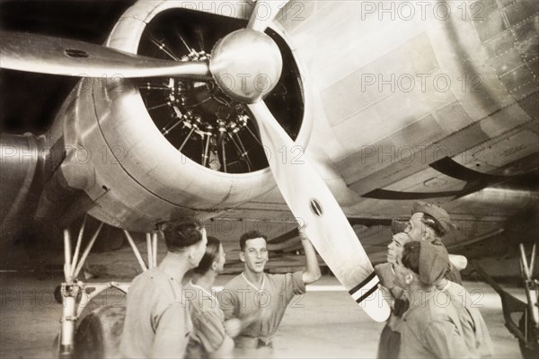 Propeller of a Royal Dutch Airlines aeroplane. European servicemen inspect the propeller of a KLM Royal Dutch Airlines aeroplane, the PH-ALV 'Valk', in a hangar in Lydda Airport. Lydda, British Mandate of Palestine (Lod, Israel), circa 1938. Lod, Central (Israel), Israel, Middle East, Asia.