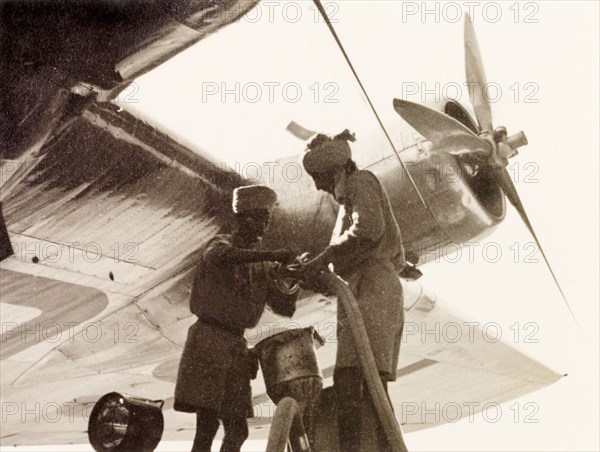 Refuelling 'Euterpe' at Dum Dum Airport. Two Indian airport workers refuel Imperial Airways aircraft 'Euterpe' at Dum Dum Airport (now Netaji Subhash Chandra Bose International Airport). Dum Dum, Calcutta (Kolkata), India, December 1938. Kolkata, West Bengal, India, Southern Asia, Asia.