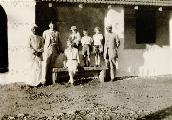 Indian evangelists with European friends. Two Indian evangelists, Mr T. Devadatta and Mr T.B. William, pose with British missionary Reverend Norman Sargant, Mrs Short and three European children by the veranda of a colonial bungalow at a Methodist mission compound. Gubbi, Mysore State (Karnataka), India, 1934., Karnataka, India, Southern Asia, Asia.