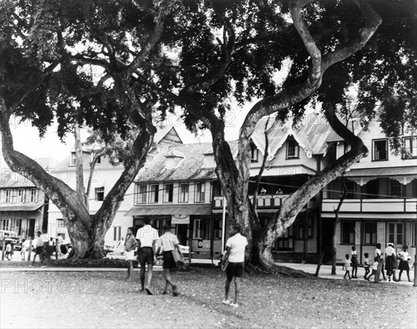 Town square in Old Castries. Schoolchildren cross a town square in Old Castries, lined with colonial-style buildings. Castries, St Lucia, 1965. Castries, St Lucia, St Lucia, Caribbean, North America .