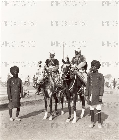 Indian dignitaries at Coronation Durbar, 1903. Two Indian dignitaries mounted on caparisoned horses, attended to by two uniformed servants, pose for a portrait at the Coronation Durbar. Delhi, India, circa 1 January 1903. Delhi, Delhi, India, Southern Asia, Asia.