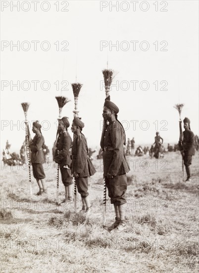 Spearmen at Coronation Durbar, 1903. Uniformed spearmen stand to attention holding ceremonial spears at the Coronation Durbar. The shafts of the spears are decorated with a stripy pattern, while the heads feature a plume of twigs, giving the spear a broom-like appearance. Delhi, India, circa 1 January 1903. Delhi, Delhi, India, Southern Asia, Asia.